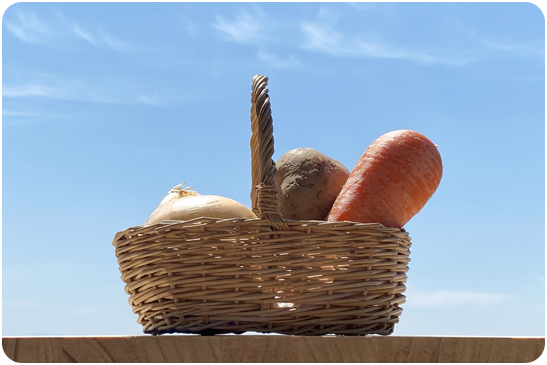 フードバンクってどんなもの？（青空とバスケットに入った野菜たち）