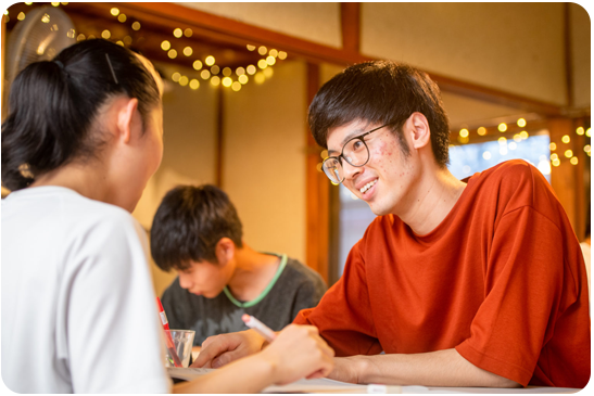 子どもと共に成長（勉強を教える学生）